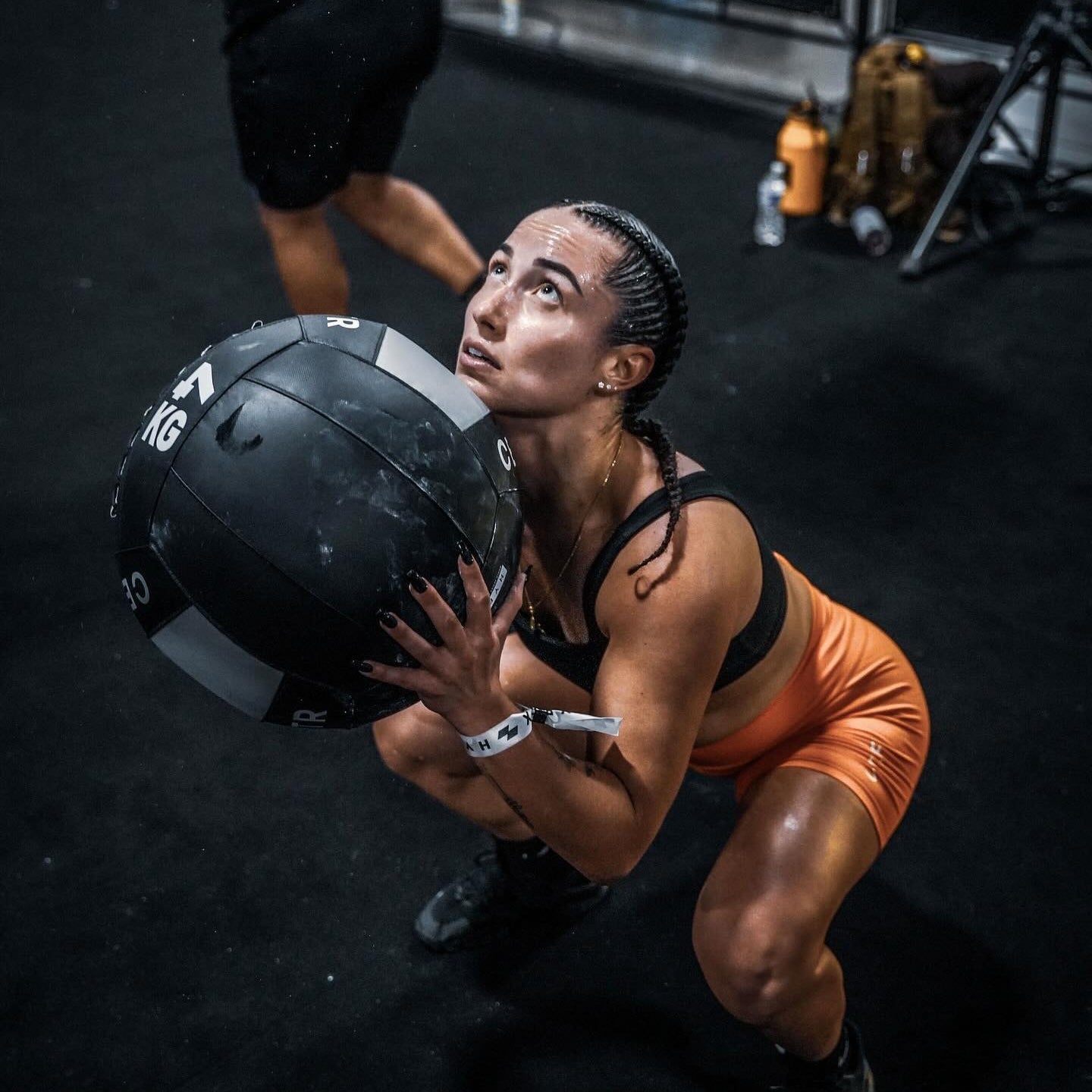 Person lifting a medicine ball in a gym setting