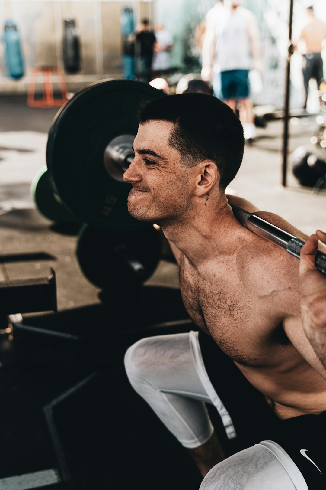 Muscular man lifting weights in a gym setting