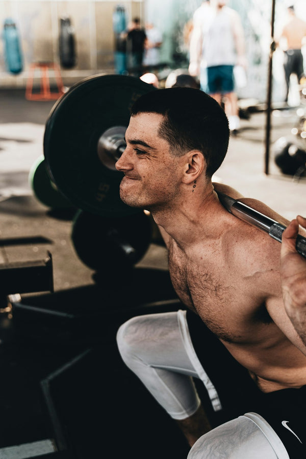 Muscular man lifting weights in a gym setting