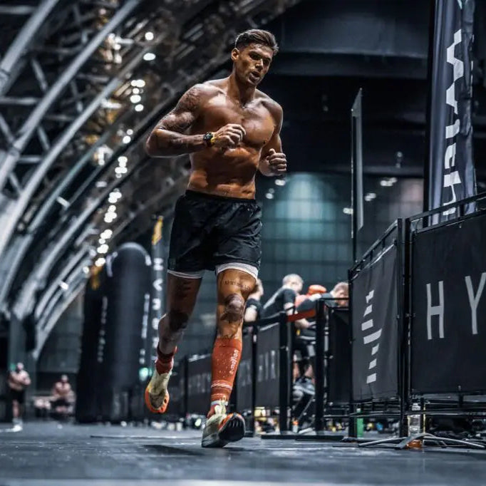 Athlete running in a dark indoor setting with 'HYRO' branding.