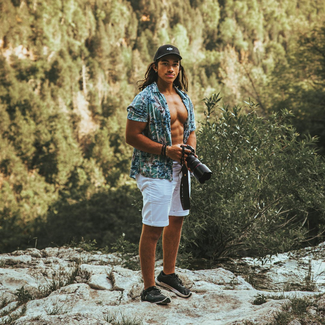 man with camera standing in forest