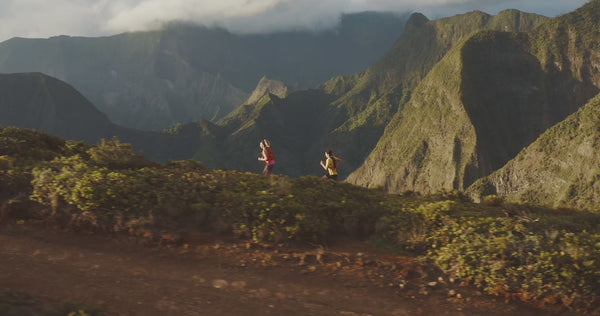 Video of two people running on a mountain ridge line 